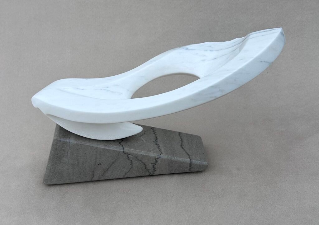 Elevated Risk by Bill Cook Jr., abstract white marble sculpture with an open center on a gray marble base
